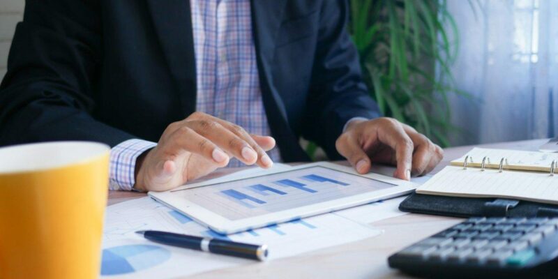 Pessoa analisando tabelas com o tablet